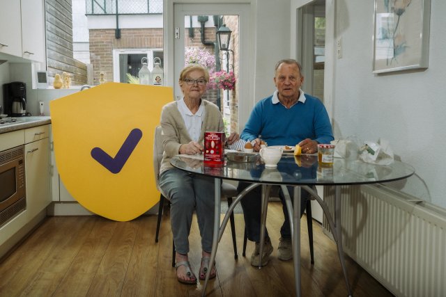 Seniore vrouw en man lunchen aan de keukentafel